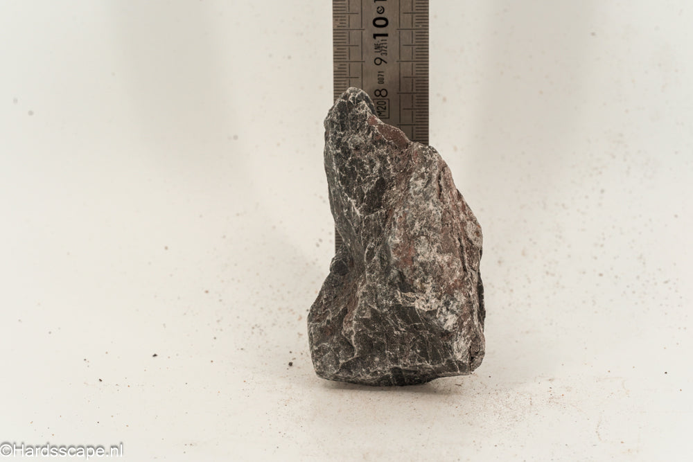 Kleine Dark Hell Stone S096 van Hardscape.nl, donkere natuurstenen keien voor tuin- of opritdecoratie, zichtbaar in de afbeelding.