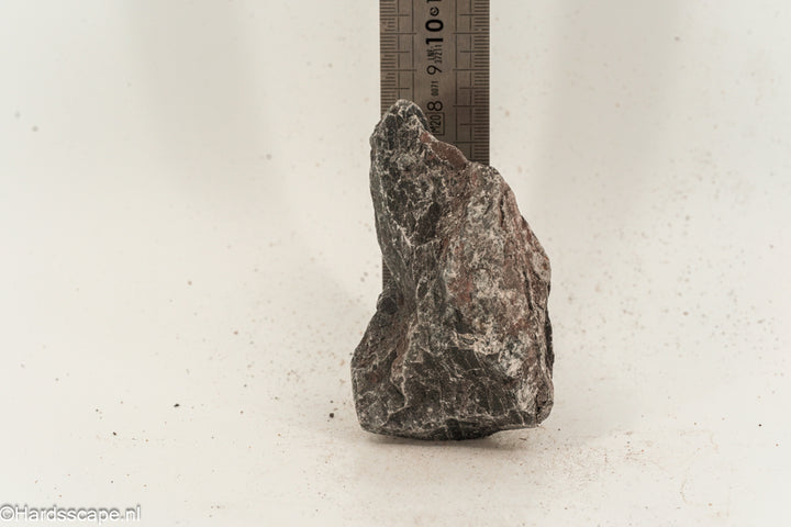 Kleine Dark Hell Stone S096 van Hardscape.nl, donkere natuurstenen keien voor tuin- of opritdecoratie, zichtbaar in de afbeelding.