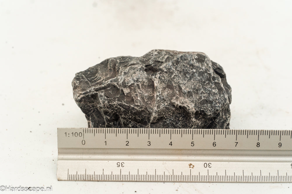 Kleine Dark Hell Stone S101 van Hardscape.nl met ruwe, donkere textuur voor tuin- of opritdecoratie.