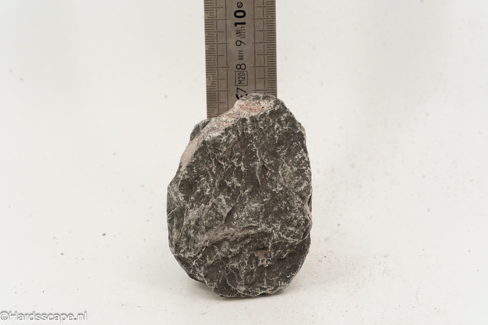 Kleine donkere hell steen S106 van Hardscape.nl, gedetailleerde textuur en natuurlijke uitstraling, geschikt voor tuin- en terrasafwerking.