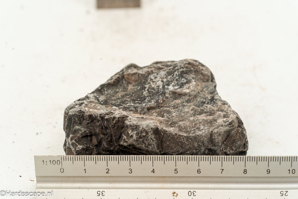 Kleine Dark Hell Stone S112 van Hardscape.nl, donkere sierstenen voor tuin- en opritdecoratie, zichtbaar in de afbeelding.