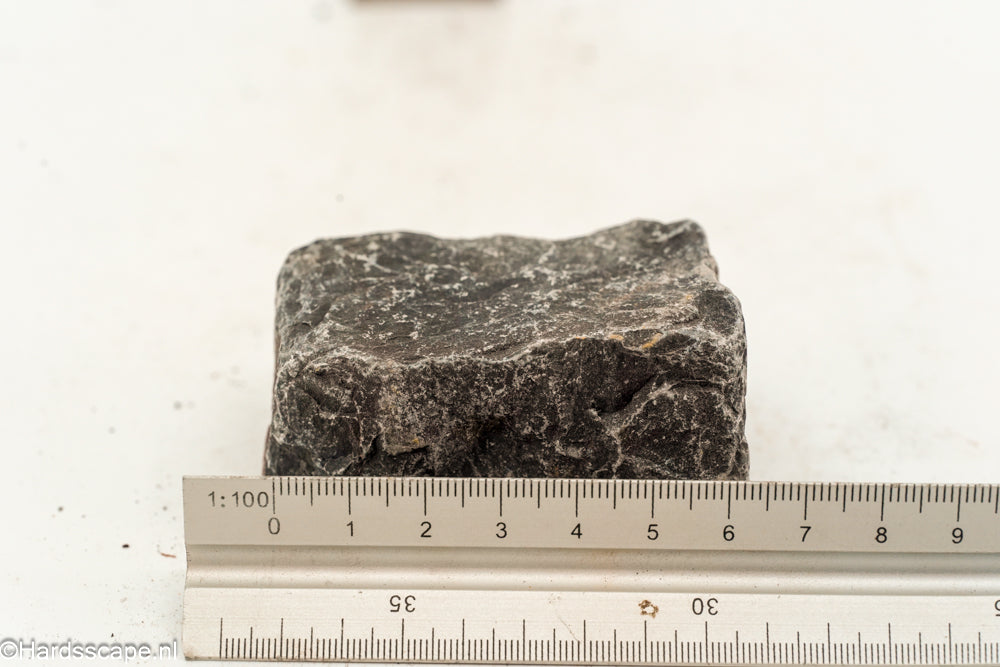 Kleine Dark Hell Stone S117 van Hardscape.nl, donkere natuurlijke steen voor tuin- en opritdecoratie, getoond in close-up.