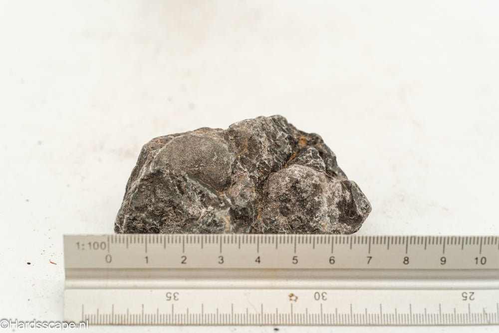 Kleine dark hell stone S124 van Hardscape.nl, donkergrijs natuursteen met ruwe textuur op een tuinpad gelegd