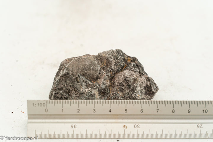 Kleine dark hell stone S124 van Hardscape.nl, donkergrijs natuursteen met ruwe textuur op een tuinpad gelegd
